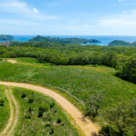 Aerial over the hillside lot toward the Pacific coastline