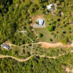 Top-down aerial with the lot boundary marked along the access road