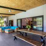 Covered outdoor living area with lounge seating and dining table