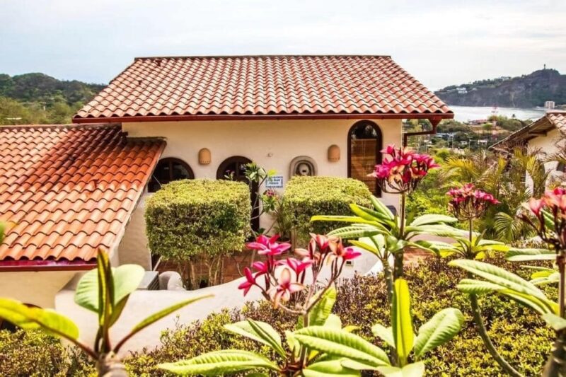 Tile-roofed villa exterior with tropical garden in Pelican Eyes