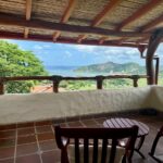Covered terrace with seating and a view over the bay