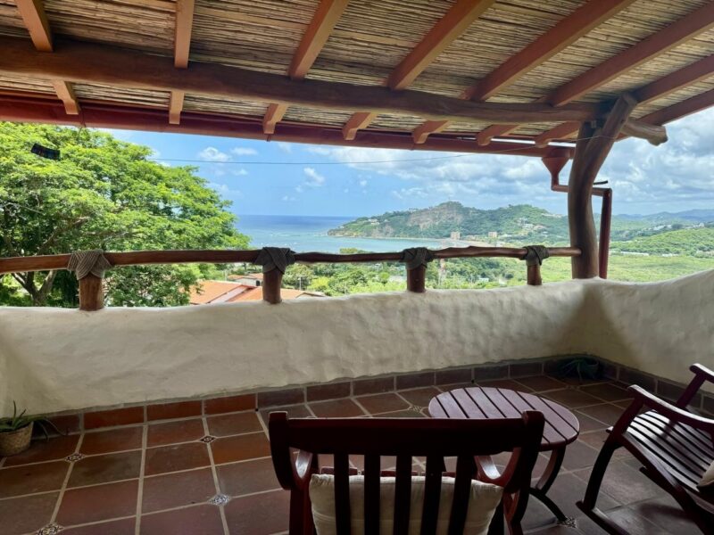 Covered terrace with seating and a view over the bay