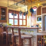Kitchen with hanging cookware and arched windows
