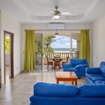 Living room with sofas opening to the ocean-view terrace
