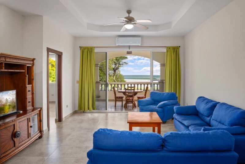 Living room with sofas opening to the ocean-view terrace