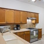 Kitchen with wood cabinetry, gas range, and refrigerator