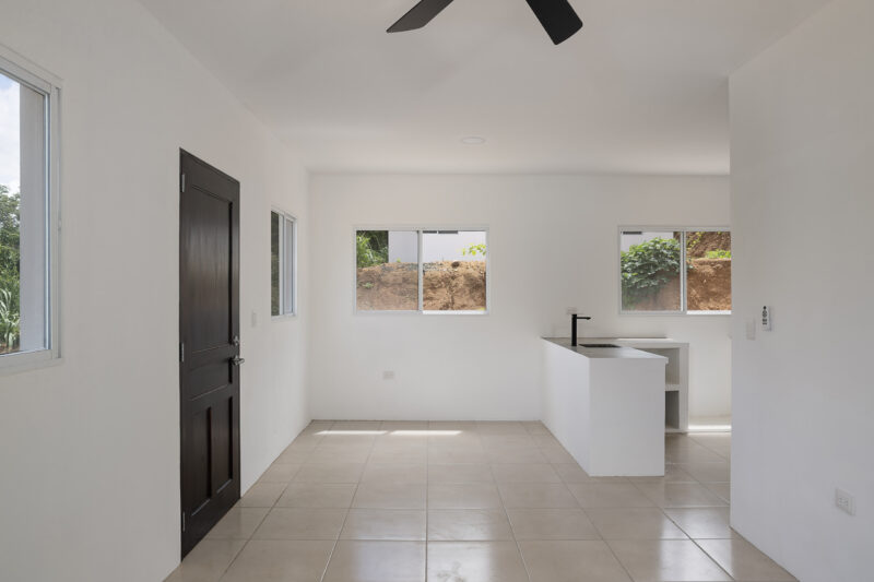 Living and dining area with natural light from wrap-around windows