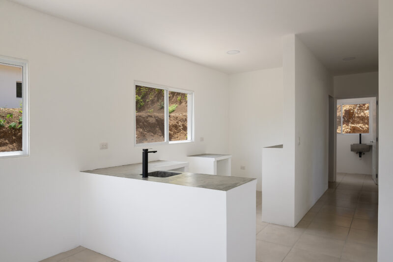 Starter home near Playa Yankee — kitchen with peninsula and hallway to bedrooms