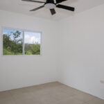Bedroom one with ceiling fan and view of the trees
