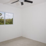 Bedroom two with ceiling fan and hillside view