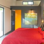 Bedroom with colorful accent wall and garden window