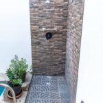 Outdoor stone shower next to the plunge pool