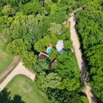 Drone view of the home and pool among mature trees in Hacienda Iguana