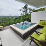 Covered patio with lounge seating beside the pool