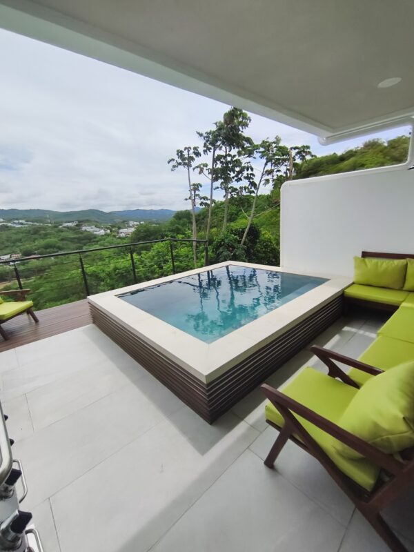 Covered patio with lounge seating beside the pool