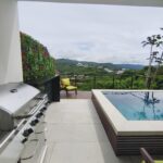 Gas grill on the deck with the pool and hillside view
